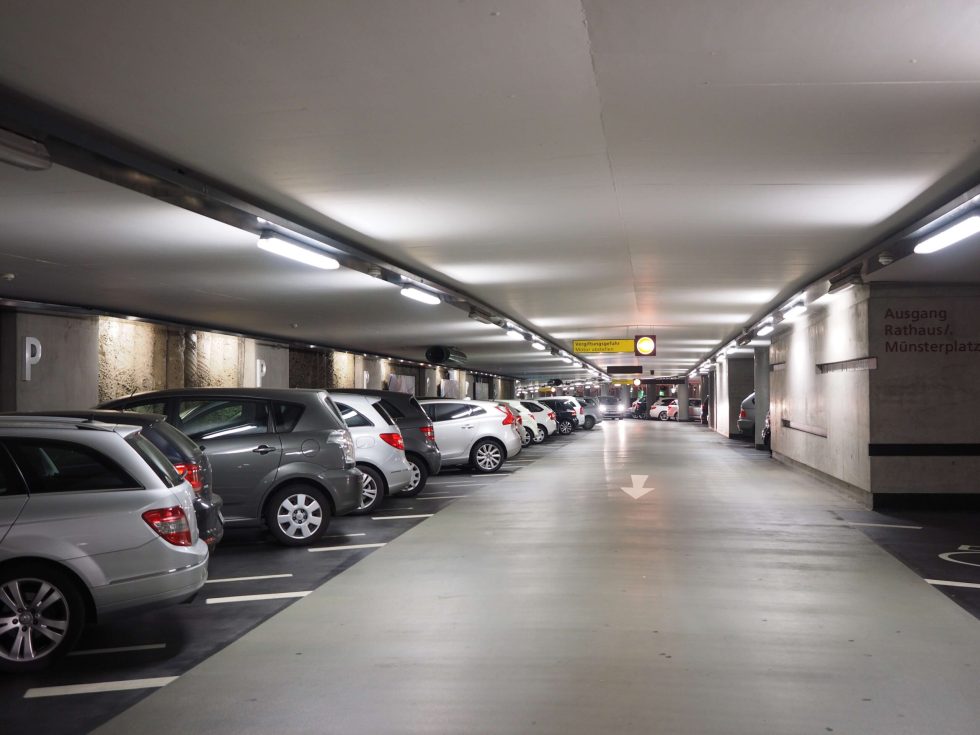 Rows of parked cars inside a public parking garage.